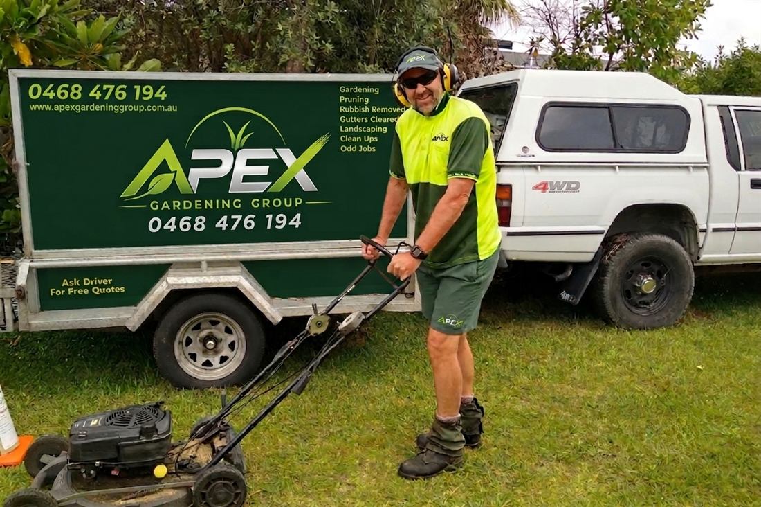 Apex Gardening Group operator with mower and sign-written trailer ready for a regular lawn service