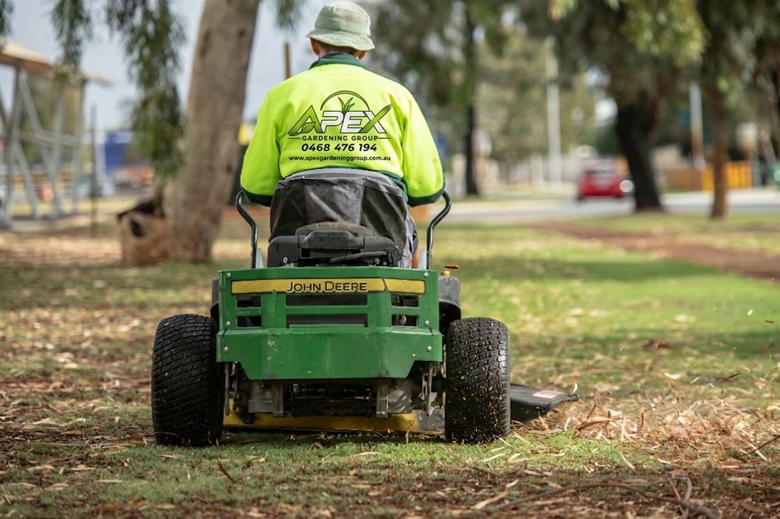 Apex Gardening Group operator on a ride-on mower maintaining large open grounds