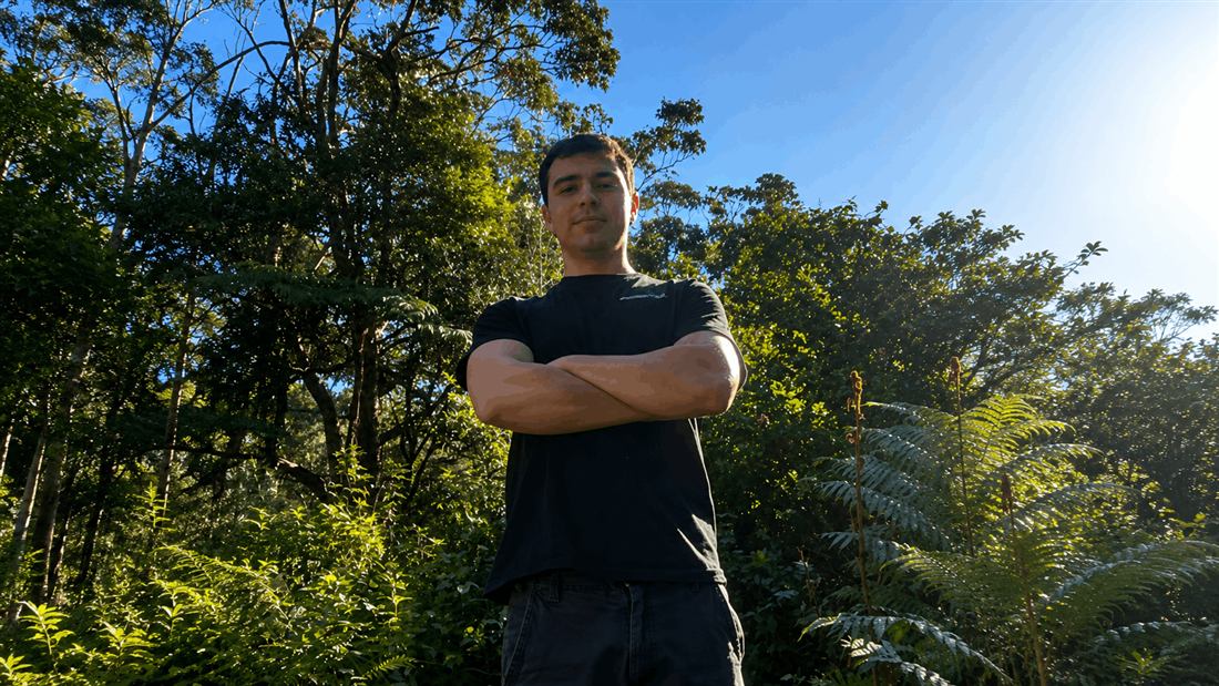 Tate from Apex Gardening Group standing in front of native bushland